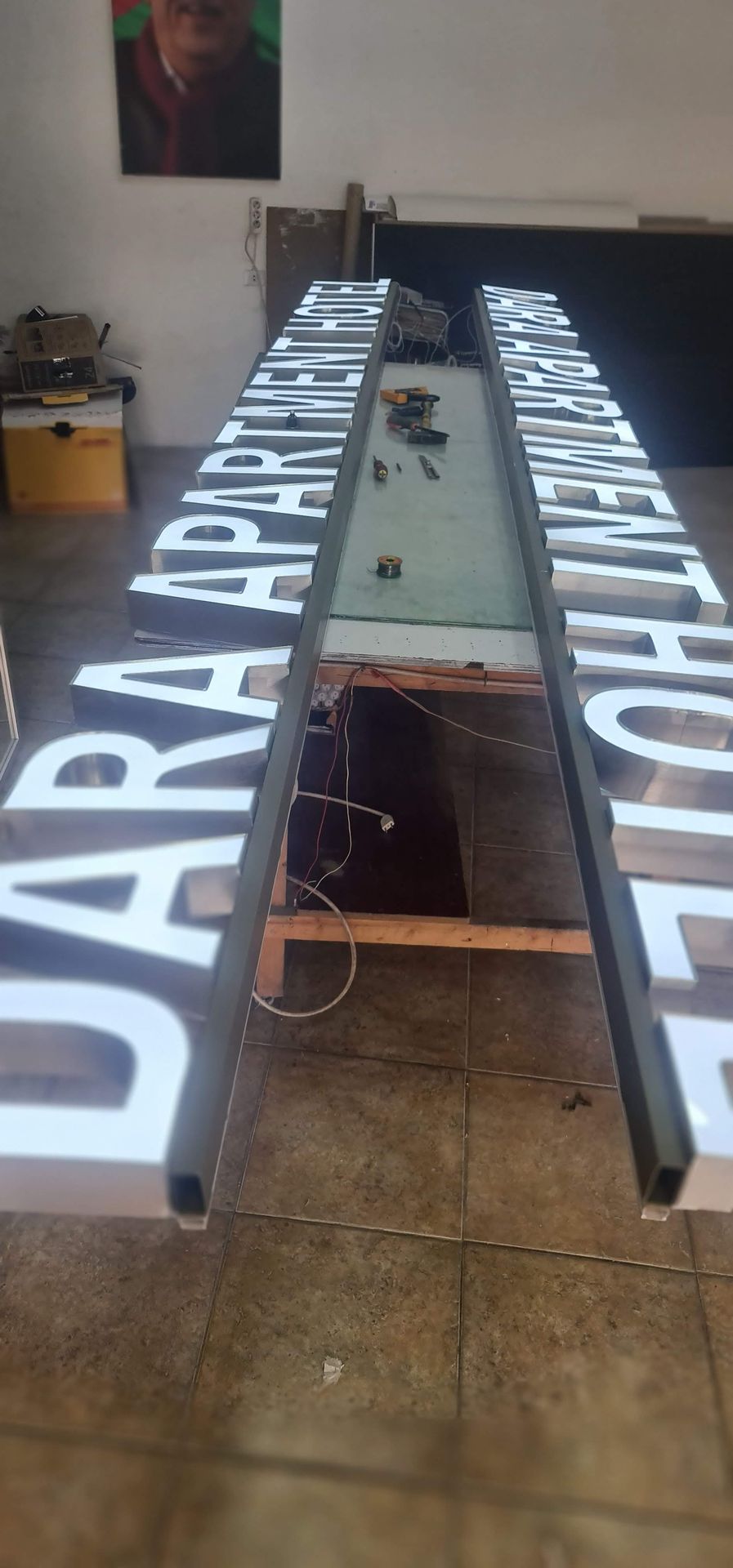 Illuminated channel letters during production on workshop table